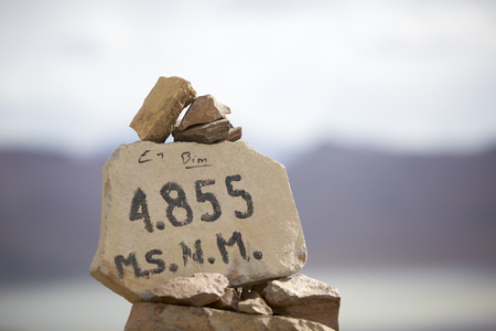 Pile of stones with the altitude of 4855 meters above the sea levels. Eduardo Avaroa National Park. Bolivia. (Selective focus on the numbers)の写真素材