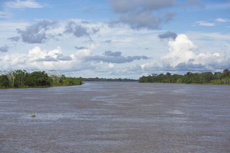 Panorama of the Amazon river and the rain forest with a cloudy blue sky. Amazon States, Brazilの写真素材