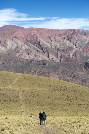 HUMAHUACA, ARGENTINA, DEC 21: Undefined group of tourists walking towards the mountain of fourteen colors, Quebrada de Humahuaca against a blue sky, Northern Argentina 2014のeditorial素材