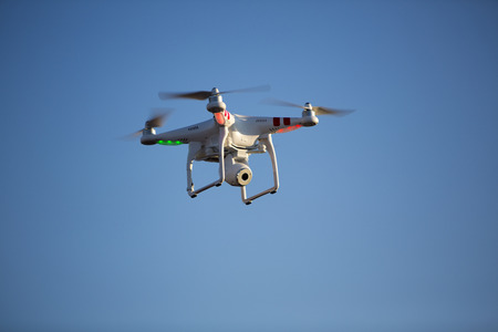 GUATAPE, COLOMBIA, MARCH 12: Flying radio controlled DJI Phantom quadcopter drone taking of in blue...