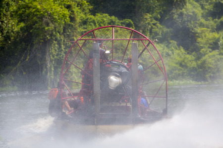Rear view of speed boat cruising on the Catatumbo river with passengers, tropical forest in the...