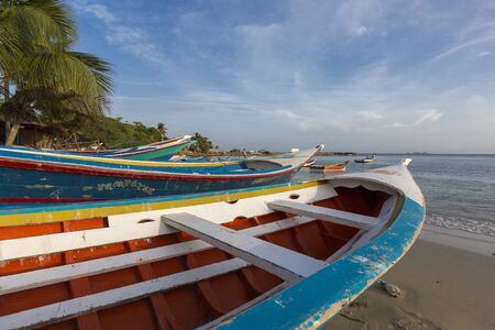 Colorful wooden fisher boats anchored in the bay of Pampatar with loads on the wooden pier. Margarita Island. Venezuelaのeditorial素材