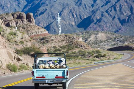 Old light green Ford pick up full bags of potatoes driving on the famous Ruta 7 road connecting Route 7 to Chile Argentina Within The Andean Mountains close to Mendoza During a sunny day. Argentina 2014のeditorial素材