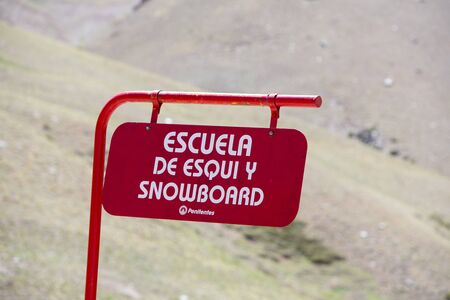 Red metallic sign board with school of snowboarding written in Spanish in Penitentes During The summer with blurred background. Mendoza closest ski resort. Argentina 2014のeditorial素材