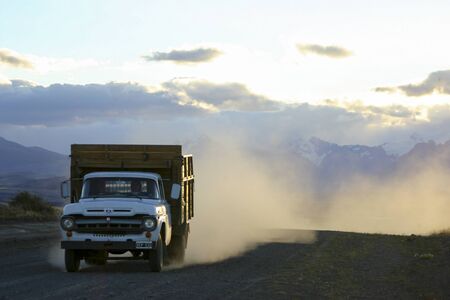 Truck traveling is dirt road in the wilderness of Patagonia with mountains in the background. Argentina 2006のeditorial素材
