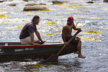 Two Indian native guides at work on wooden traditional canoe in Caroni River at Canaima National Park, Bolivar State. Venezuela, in 2015.のeditorial素材