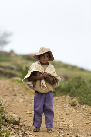Portrait of young Bolivian small boy standing and looking at the camera on Moon Island Isla del Sol, Copacabana. Bolivia 2015のeditorial素材