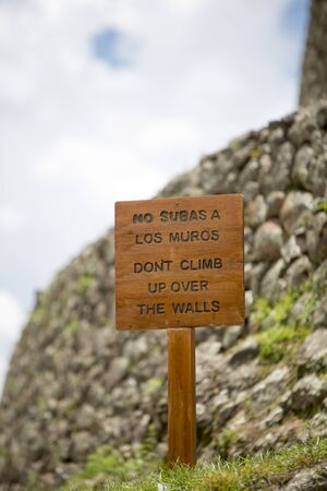 PISAC, PERU, JANUARY 15: Closeup on wooden sign with No subas a los muros (Don't climb up over the walls) written in Spanish at the Pisac Inca Ruins near Cusco. Peru 2015のeditorial素材
