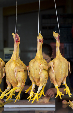 Three yellow chickens hanging in raw food marketplace in Huaraz, Peru 2015の写真素材