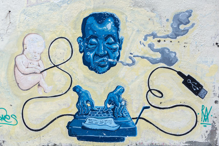 Graffiti art and street murals with head of man smoking and typing on keyboard with baby floating USD and Cable in the city of Cali. Colombia 2015のeditorial素材