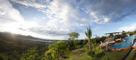 Panorama of swimming pool with tourists with tropical mountains in the background in Rurrenabaque, the gateway to the Bolivian Amazon rain forest. Bolivia 2015のeditorial素材