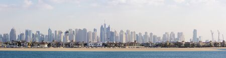 Paradise Island with modern villas with Marina High luxury blue skyscrapers in the background. Dubai, United Arab Emirates 2016.のeditorial素材