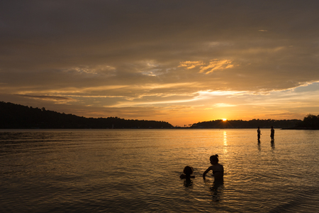 Romantic sunset beach with silhouette people in the water. Thailand, Koh Chang Islandの写真素材