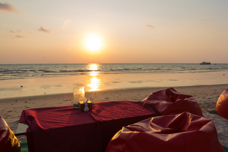 Sunset and ready table for dinner at the beach on Koh Chang Island in Thailand. Perfect romantic scene.の写真素材