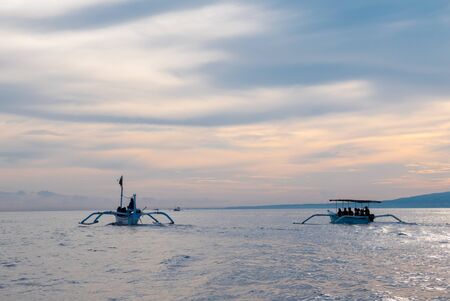 Traditional small wooden boats with groups of tourists looking for dolphins in Lovina, Bali. Indonesia, 2016.の写真素材