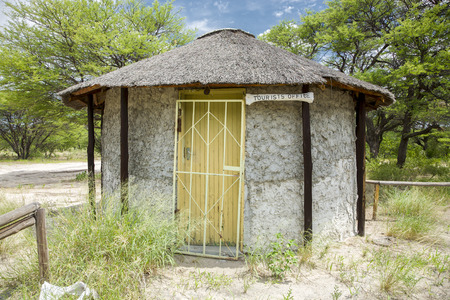 Traditional African hut with the tourist office in Central Kalahari Game Reserve with the bush in the background. Botswanaの写真素材
