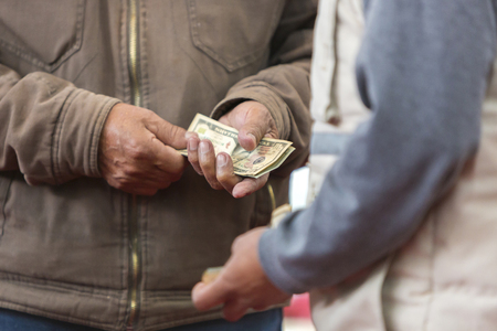 Hand receiving send money from cockfight loser owner in Otavalo, Ecuador. Defocussed foreground.の写真素材