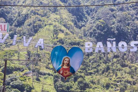 Religious sign suspended to a cable with the greeting words Viva Banos written is Spanish in...