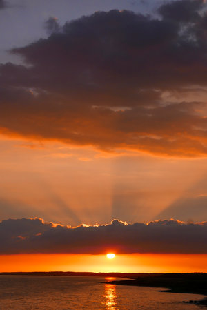 Tranquil red and orange sunset over ocean and beach near Havneby in Denmarkの写真素材