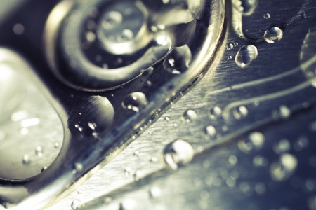 Closeup on the detail of the lid of a cold drinks can with condensation drops on the top....