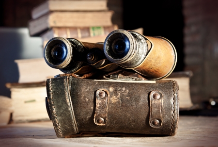 Vintage binoculars and their case, with travel books in the background の写真素材