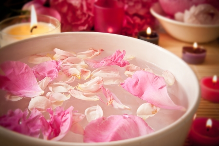 An arometherapy scene, with aromatic oils and petals in the water and candles  Focus on the petals  Spa scene の写真素材