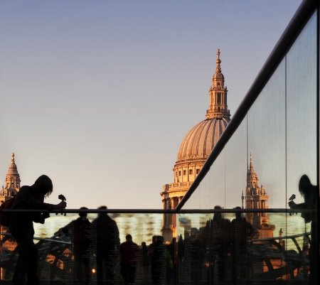Tourists at dusk on Millennium Bridge, with a detail of St Paulの写真素材