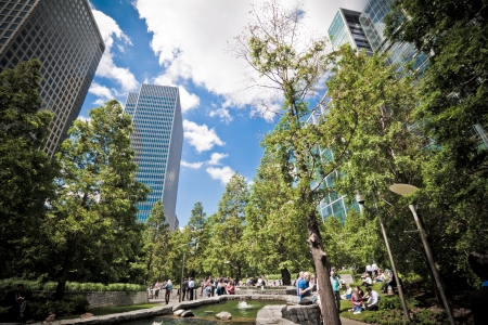 London, 3 June 2011: office workers enjoying the gorgeous summer weather at lunchtime, in London's financial district at the Docklands. Jubilee Park, Canary Wharf, Docklands, London. Landscape orientation.のeditorial素材