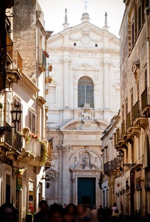 A view of the main street in Lecce with the crowds promenading in the late afternoon sun  The church of St Irene, built from 1591 by Francesco Grimaldi, provides the backdrop のeditorial素材