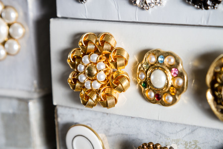 Boxes of precious, jewel-like vintage buttons stacked in rows in a haberdashery.の写真素材