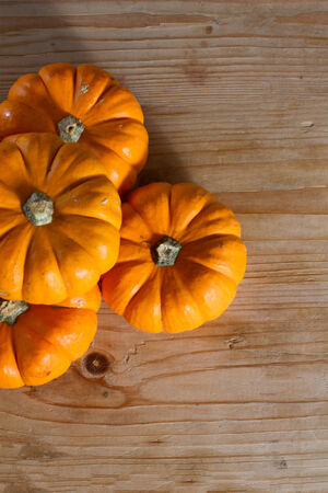 Festive bright orange pumpkins against wooden background. Copy space.の写真素材