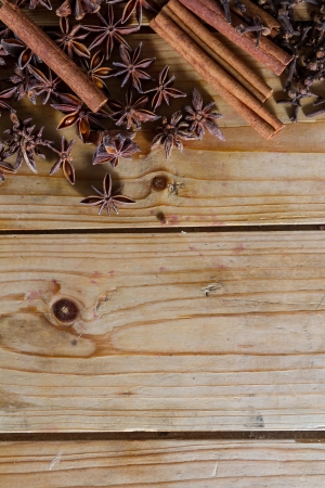 Assorted spices for food and decoration, against a rustic wooden background: cinnamon, star anise, cloves. Plenty of copy space.の写真素材