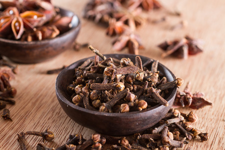 Spices series: a bowl full of cloves against a wooden background. Copy space.の写真素材