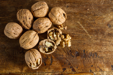 Autumnal fruits: walnuts against wooden rustic background.の写真素材