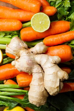 Ingredients for a healthy juice or soup: carrots, celery, lemon and ginger.の写真素材