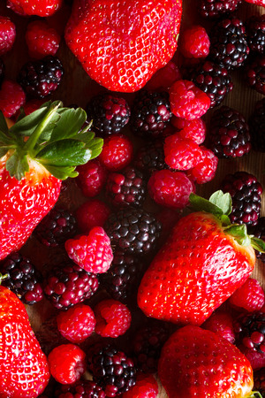 Fruits of the forest: strawberries, raspberries and blackberries against wooden background.. Healthy breakfast food.の写真素材