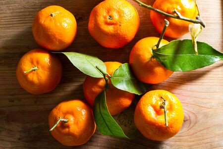 Juicy, fresh clementines against a wooden background.の写真素材