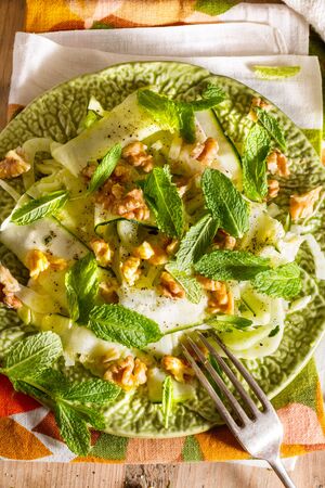 Healthy eating: raw fennel salad with walnuts, raw courgettes, mint leaves and lemon juice. Zesty, fresh, summery and light food. Perfect for a diet.の写真素材