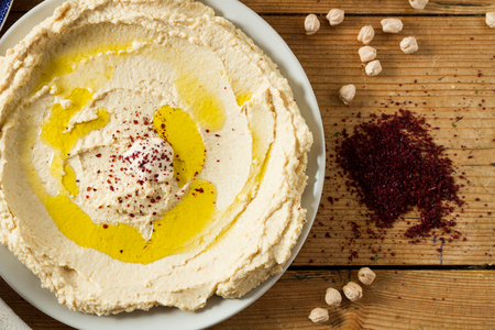 Middle Eastern cuisine: freshly made hummous, a spread made from chickpeas and seasoned with sumac and oil. Served with flat bread.の写真素材