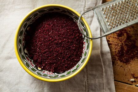 Middle Eastern cuisine: close-up on bowl of sumac. Sumac powder is used in Arabic cuisine to add zest and flavour to dishes.の写真素材