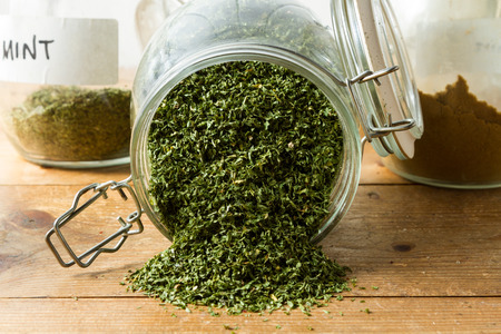 Middle Eastern cuisine: a jar of dried parsley with other herbs in the background.の写真素材