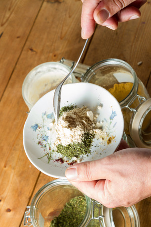 Middle Eastern cuisine: chef mixing spices and herbs to give flavour to the food. On the plate is dried parsley being mixed with powdered garlic.の写真素材