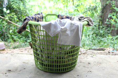 Pile of clothes overflow plastic laundry basket for washing