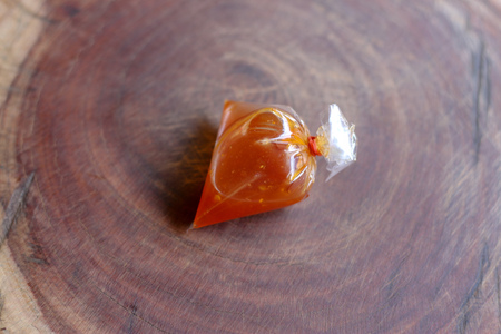 Sweet chili sauces in clear plastic bag on wooden background