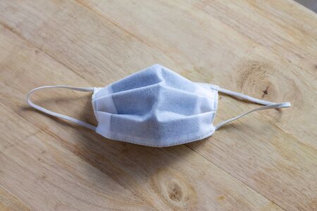 Protective mask on a wooden table. 3 layers of surgical masks generally to cover the mouth and nose....