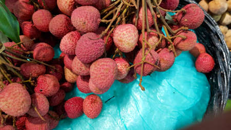 Red lychees are placed for sale in a shop in Thailand.の写真素材