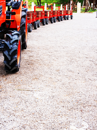 A red trailer used for transport commuters in an amusement park.の写真素材