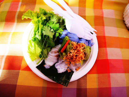 A Thai dessert composed of filling made of pork and peanut wrapped by pieces of rice flour.They are cooked by using  boiling steam and served in a dish with vegetables and coriander.の写真素材