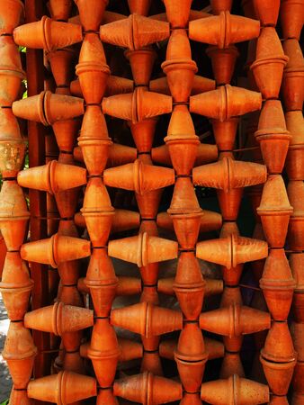 Orange clay pots are piled up to be a figure of art.の写真素材