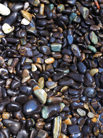 A part of round , black and glistening stones on Hin Ngam island , Tarutao National Park, Thailand.